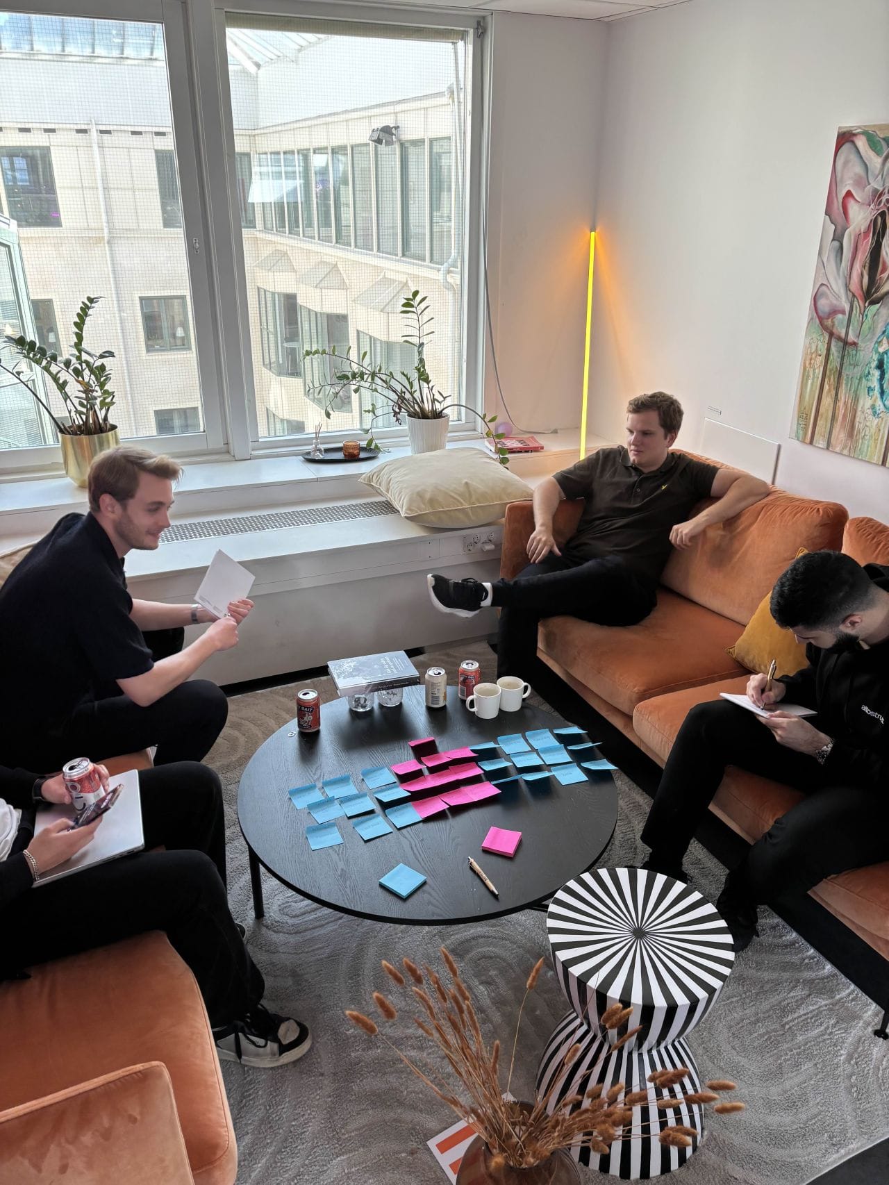 Deltagare arbetar med post-it-lappar runt soffbordet i loungen på Walborg Cowork