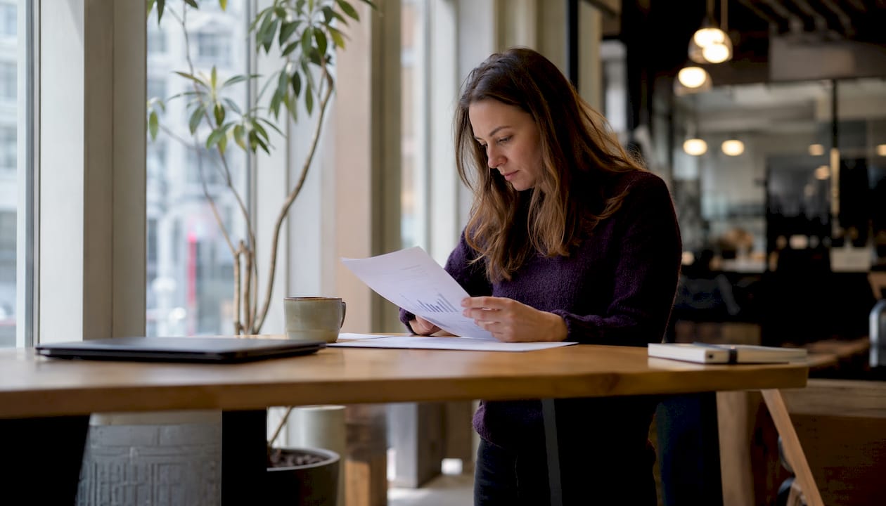 En ung entreprenör som sitter i ett coworking-space och går igenom viktiga finansieringspapper.