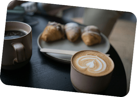 Kaffekoppar och croissanter på ett bord