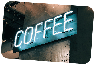 Lysande neonskylt med texten Coffee på en fasad