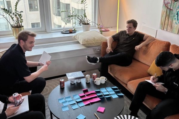 Deltagare arbetar med post-it-lappar runt soffbordet i loungen på Walborg Cowork