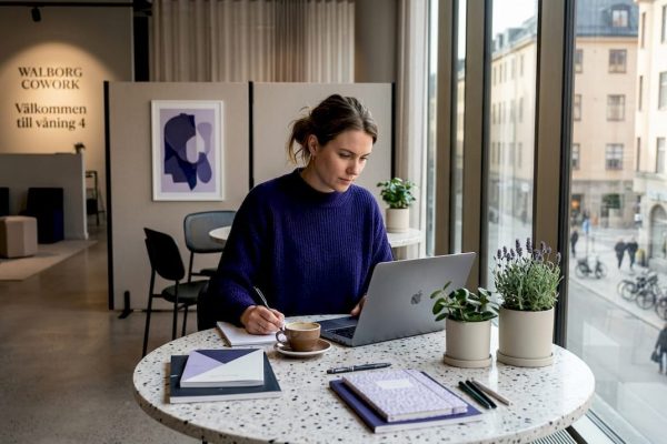 Entreprenör som jobbar vid ett kreativt och energifyllt kontorsbord tillsammans med andra.