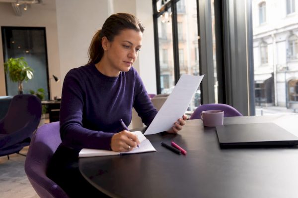 En kvinna går igenom ett avtal på ett coworkingkontor.