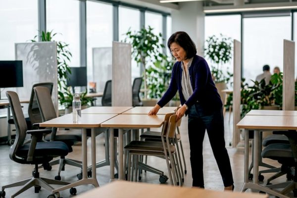 En kvinna möblerar om i ett ljust kontor med flexibla kontorsmöbler.