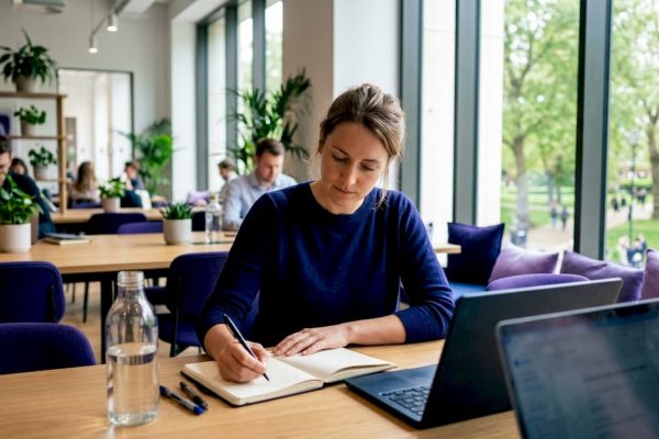 Frilansare sitter och jobbar i en ljus och inspirerande coworkingmiljö.