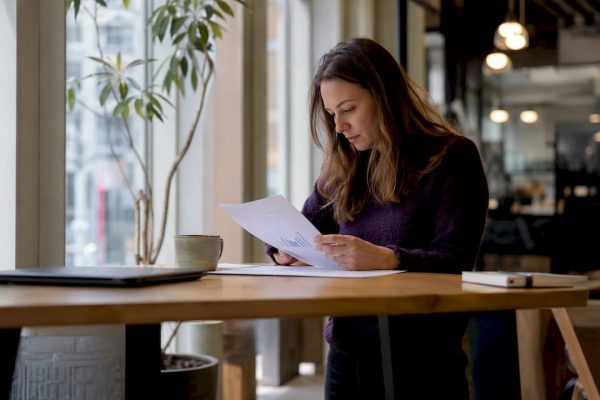 En ung entreprenör som sitter i ett coworking-space och går igenom viktiga finansieringspapper.
