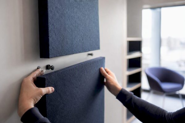 Händer som monterar akustikpaneler på kontor